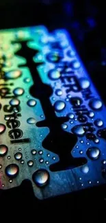 Colorful razor blade with water droplets on a dark background.