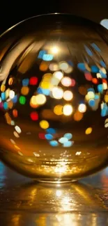 Golden glass sphere with colorful bokeh lights on display.