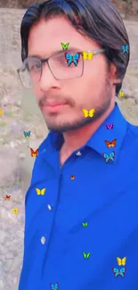 Portrait with vibrant blue shirt and colorful butterfly overlay.