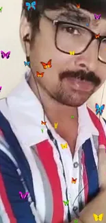 Man in striped shirt with colorful butterflies overlay.