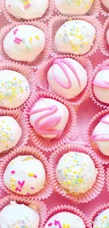 Pink and white decorated cake pops in pastel liners.