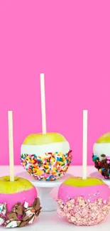 Colorful candy apples on pink background.