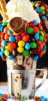 Colorful dessert topped with candy and cream in a tall glass.