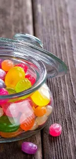 Colorful candy jar on wooden surface wallpaper.