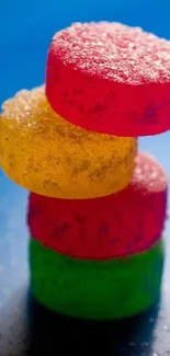 Stack of colorful, sugar-coated candies against a vivid blue background.