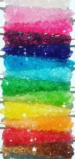Colorful candy sticks arranged in a gradient pattern on a mobile wallpaper.