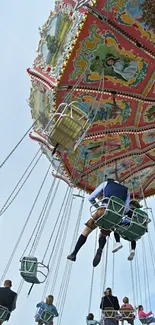 Colorful carnival swing ride against a blue sky.