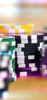 Stacked vibrant casino chips on a wooden table.