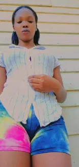 Portrait of a woman in colorful tie-dye shorts and a striped shirt.