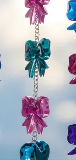 Colorful chain of metallic bows against light sky background.