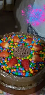 Chocolate cake with strawberries and colorful candies on top.