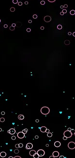 Mobile wallpaper with pink circles and blue hearts on a black background.