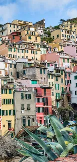 Vibrant cliffside village with ocean view and colorful houses.