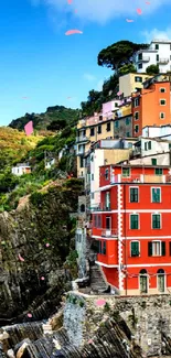 Vibrant coastal village with colorful houses beside a bright blue sea.