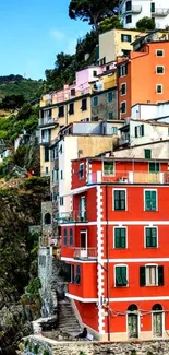 Vibrant coastal village with colorful buildings on cliffs.