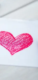 Artistic red crayon heart on white paper