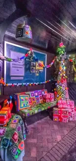 Colorful crochet tapestry and pillows at a cozy bus stop.