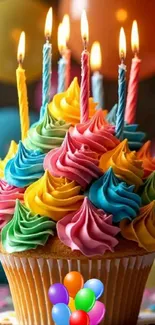 A colorful cupcake with frosting and lit candles, perfect for celebrations.