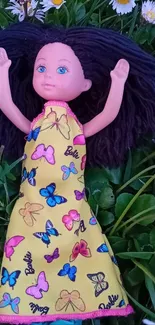 Doll in a butterfly dress surrounded by daisies.