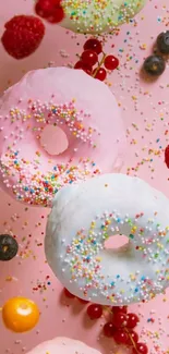 Colorful donuts with sprinkles on a pink background, surrounded by berries.