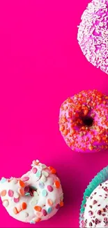 Colorful donuts on bright pink background mobile wallpaper.