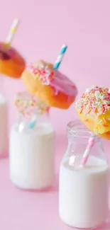 Colorful donuts on milk bottles with pink background.