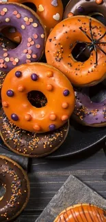 Colorful Halloween-themed donuts on dark backdrop.