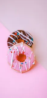 Colorful donuts on a pink and gray background wallpaper.