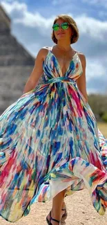 Woman in a colorful dress near ancient ruins.