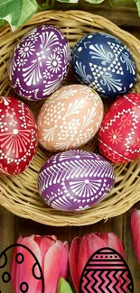 Colorful Easter eggs in a wicker basket with tulips on a wooden table.