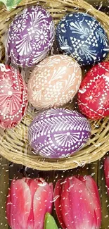 Colorful Easter eggs in a basket with tulips and green leaves.