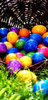 Vibrant Easter eggs scattered from a basket on green grass.