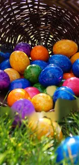 Mobile wallpaper of colorful Easter eggs in a basket on green grass.