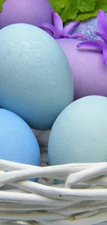 Colorful Easter eggs in a wicker basket with flowers.