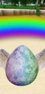 A colorful egg with white wings beneath a rainbow on sand.