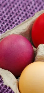 Vibrant colorful eggs in a textured carton setting.