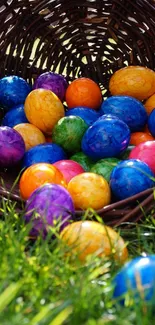 Colorful Easter eggs spilling from a wicker basket onto green grass.