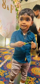 Young child at a colorful festive event with vibrant decorations.