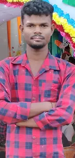 Person at a vibrant event with floral decorations and a red shirt.