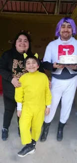 Happy family in colorful costumes celebrating with a cake.