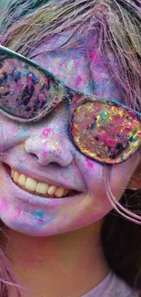 A smiling face covered in vibrant, colorful festival powder.
