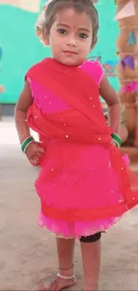 Child in vibrant traditional dress on a festive background.