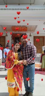 Couple in festive attire outside a decorated entrance.