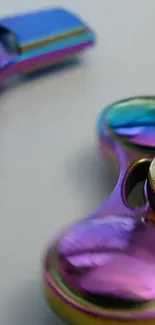 Closeup of a rainbow-colored fidget spinner with a metallic finish.