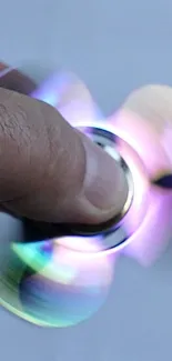 Colorful spinning fidget spinner with LED lights creating a dynamic blur effect.