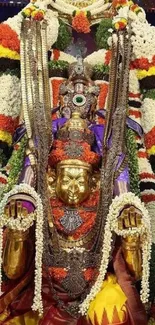 Colorful deity adorned with floral garlands and ornaments.