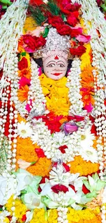 Mobile wallpaper of a deity adorned with vibrant floral garlands.