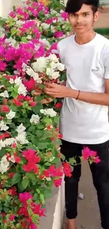 Young person with vibrant pink and white flowers in a lush garden.