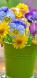 Vibrant flowers in a green pot with a blurred background.