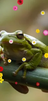 Green frog on branch with colorful flowers.